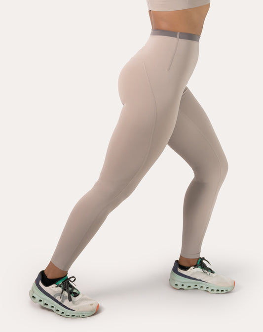 Left side close-up of beige leggings showing high-waist fit and flat, chafe-reducing seams