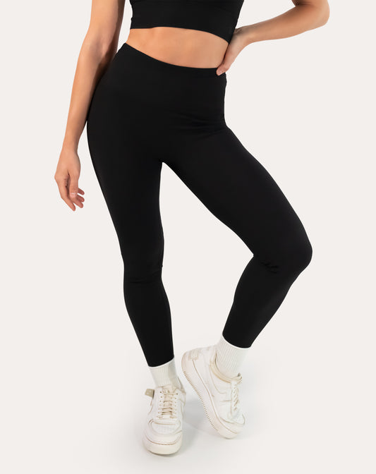 Black ribbed leggings with seamless high-rise waistband; front step view