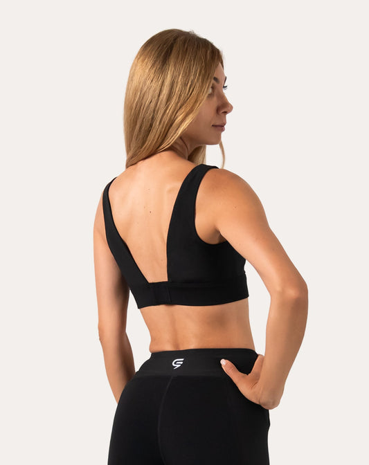 Left back three-quarter view of black running sports bra with deep V hook-back closure