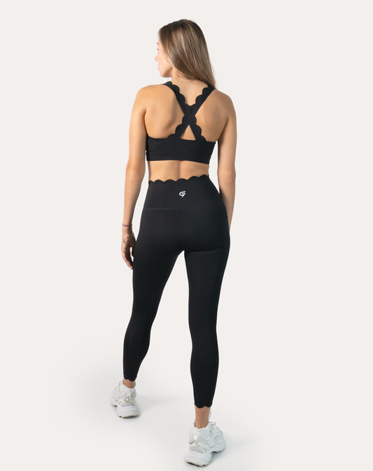 Back full-length view of black seamless gym set with cross-back straps and scalloped edges