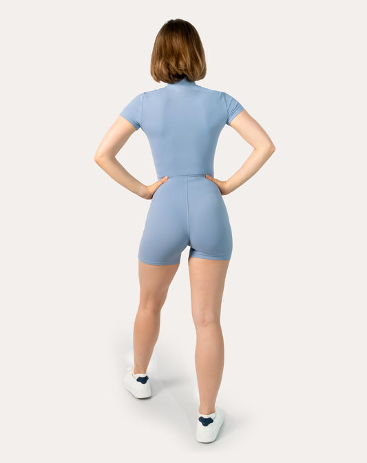Blue sports jumpsuit with short sleeves; straight back full-length view