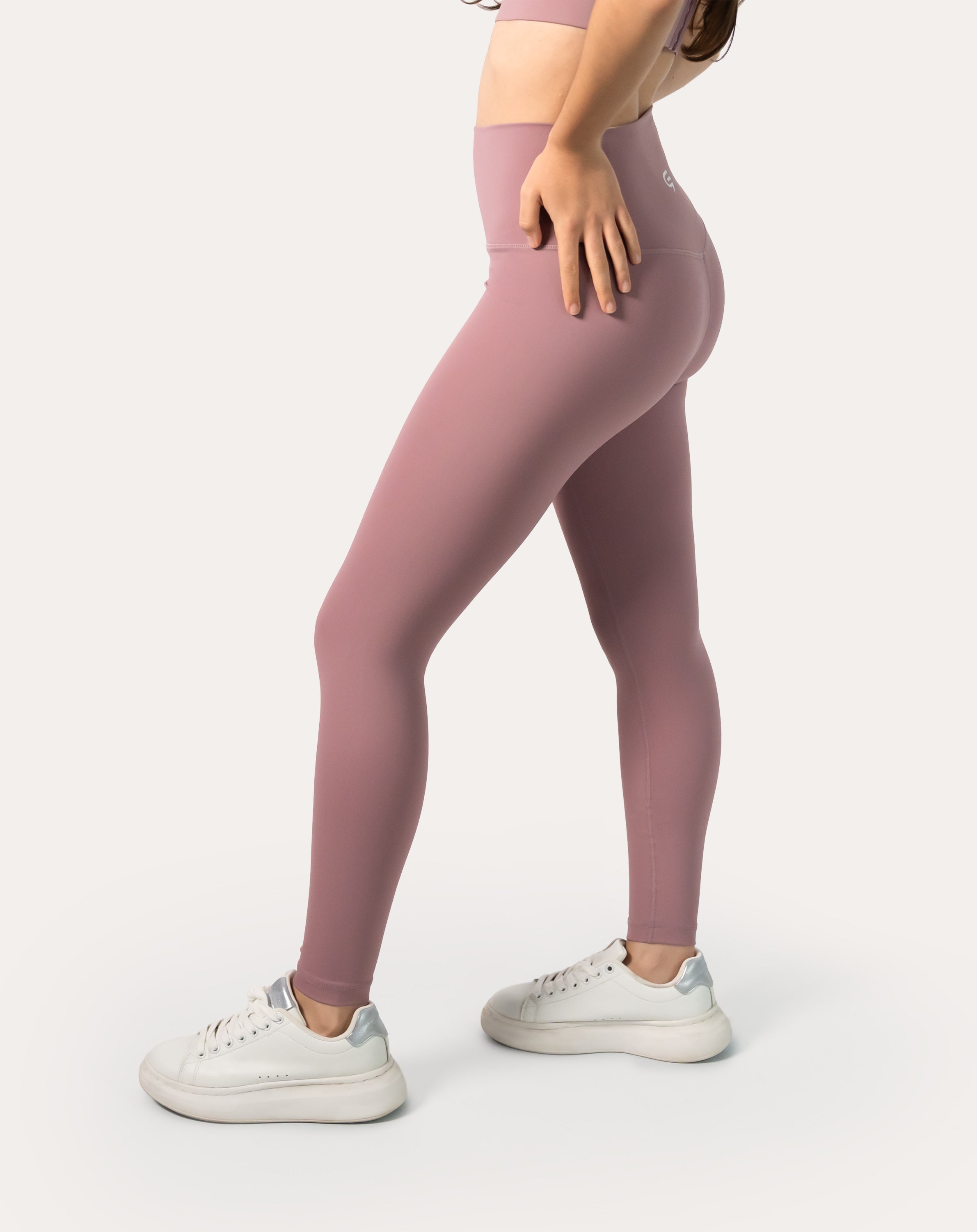 Side stretch pose demonstrating four-way stretch and squat-proof coverage on mauve leggings