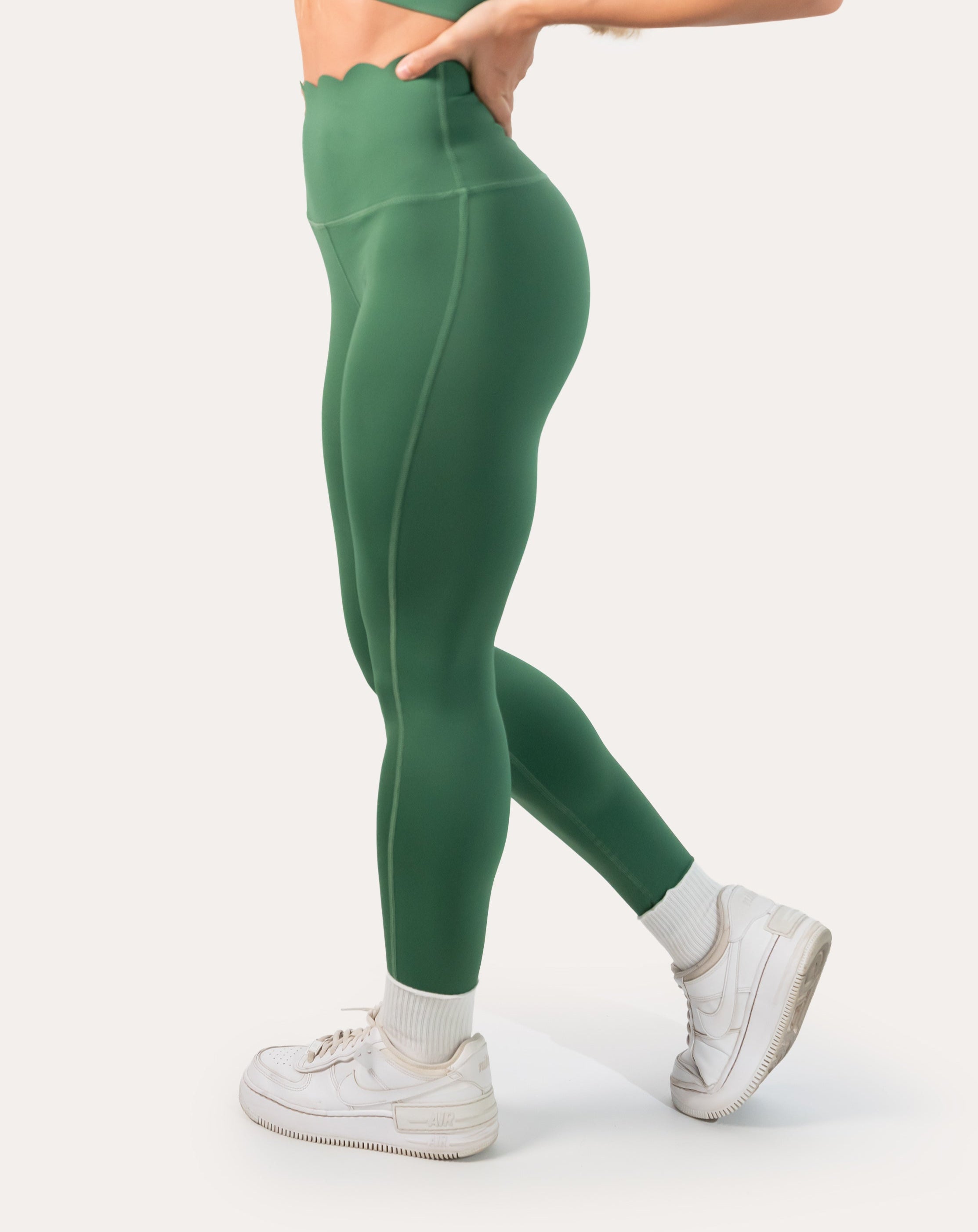 Leggings side detail from the emerald green gym set, scalloped waistband and smooth knit