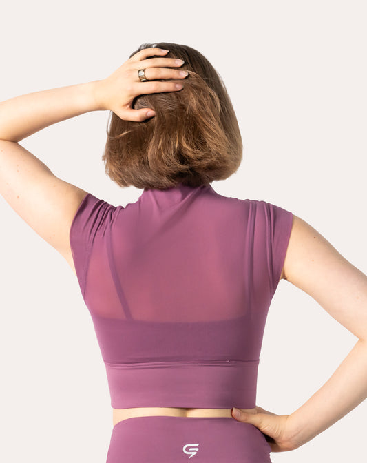 Back view showing the sheer mesh yoke and cap sleeves on the purple high neck gym top; cropped, supportive band
