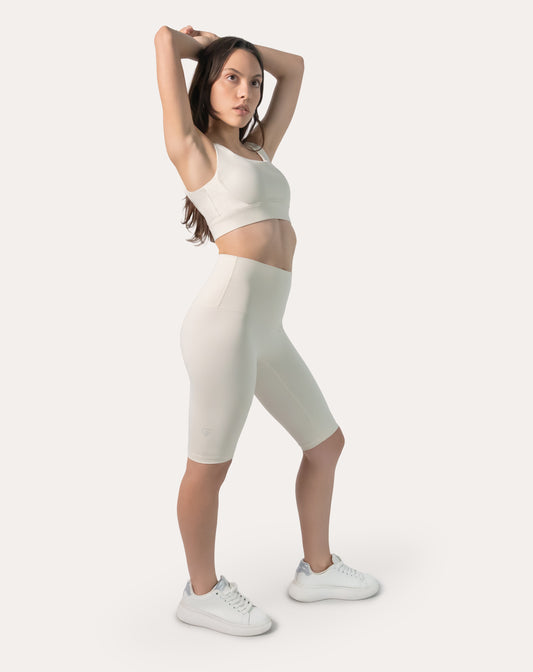 Full-body front three-quarter view of ivory high-waist longline bike shorts