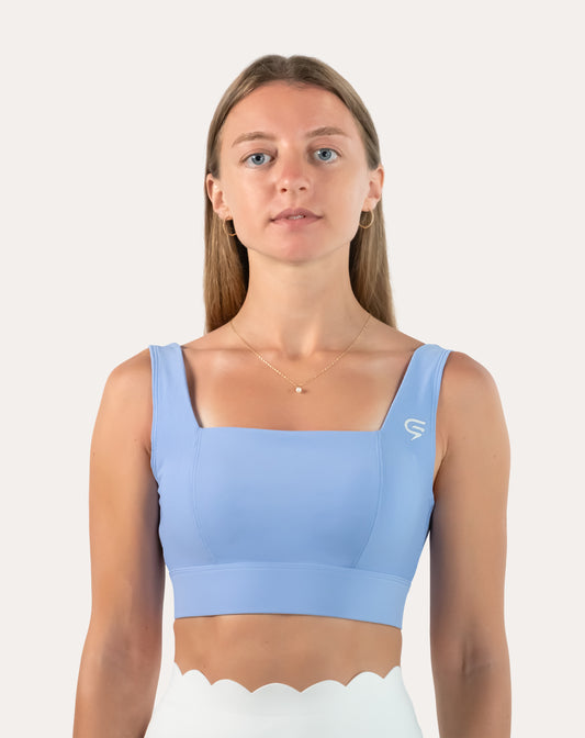 Front view of light blue square neck sports bra with rib side panels and firm underband