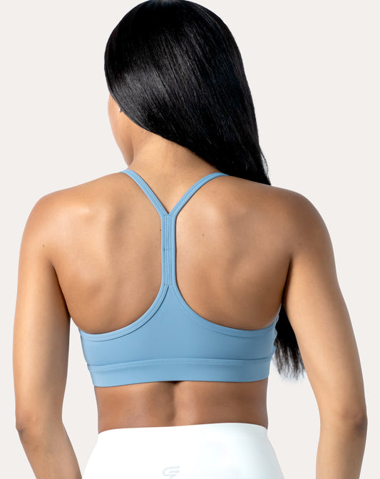 Back view of light blue strappy sports bra highlighting racerback and elastic underband