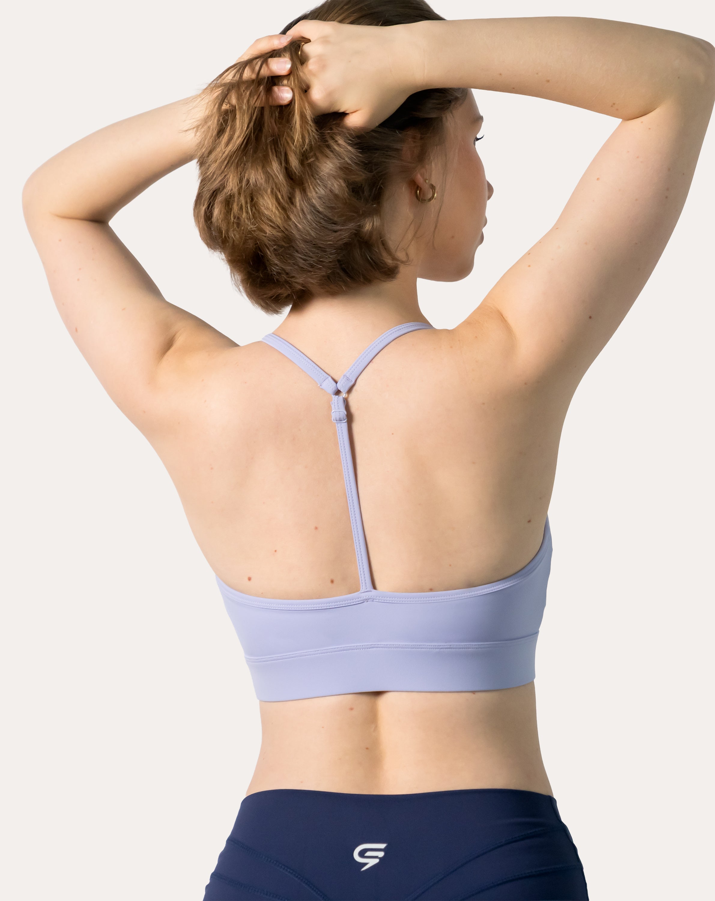 Close-up of lilac racerback sports bra’s T-back strap detail