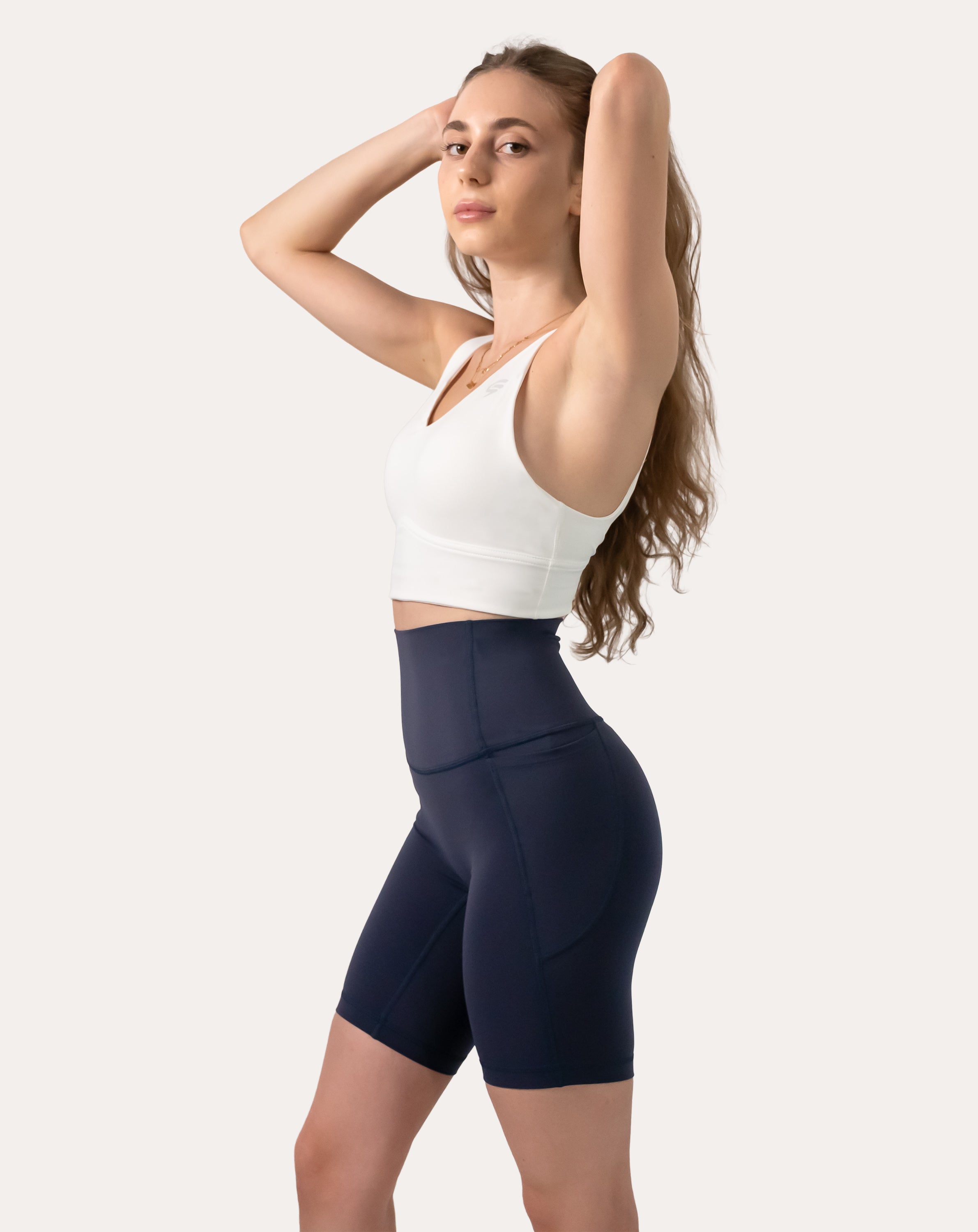 Full-body front three-quarter of navy high-waist biker shorts with dual side pockets