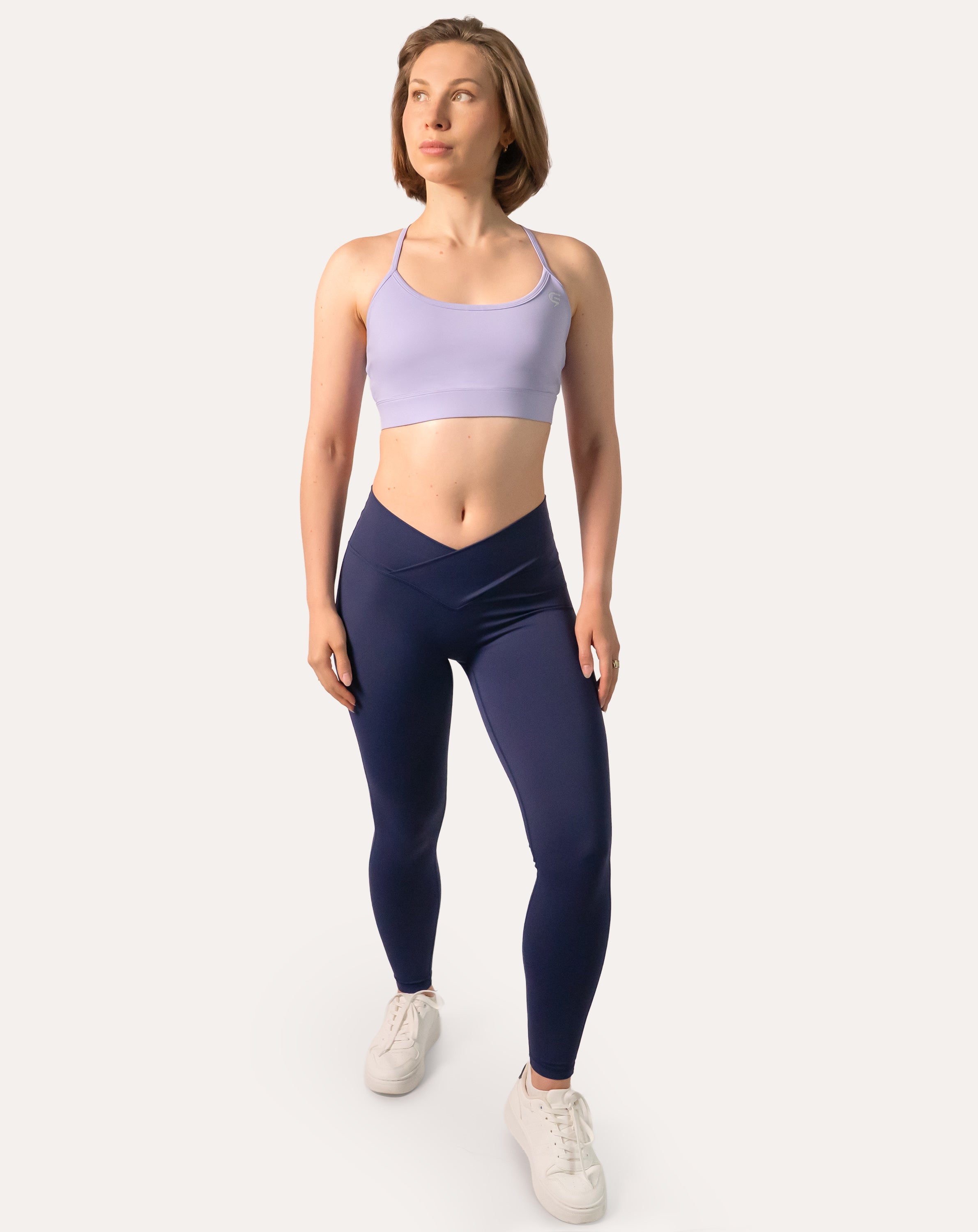 Navy scrunch bum leggings with crossover V-waist; front full-length view