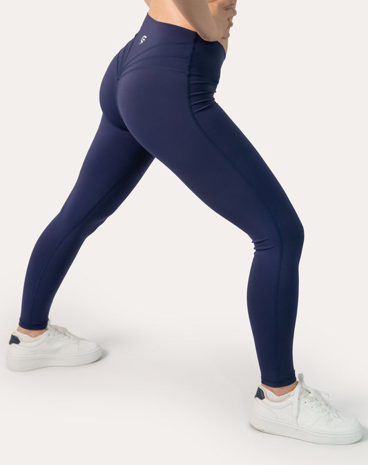 Navy scrunch bum leggings with crossover V-waist; left three quarter side view