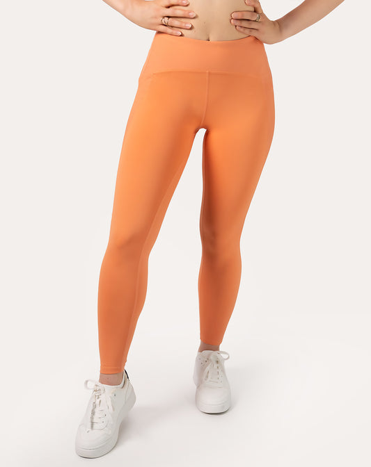 Orange gym leggings with high waisted fit; front waist-to-ankle close-up, squat-proof coverage