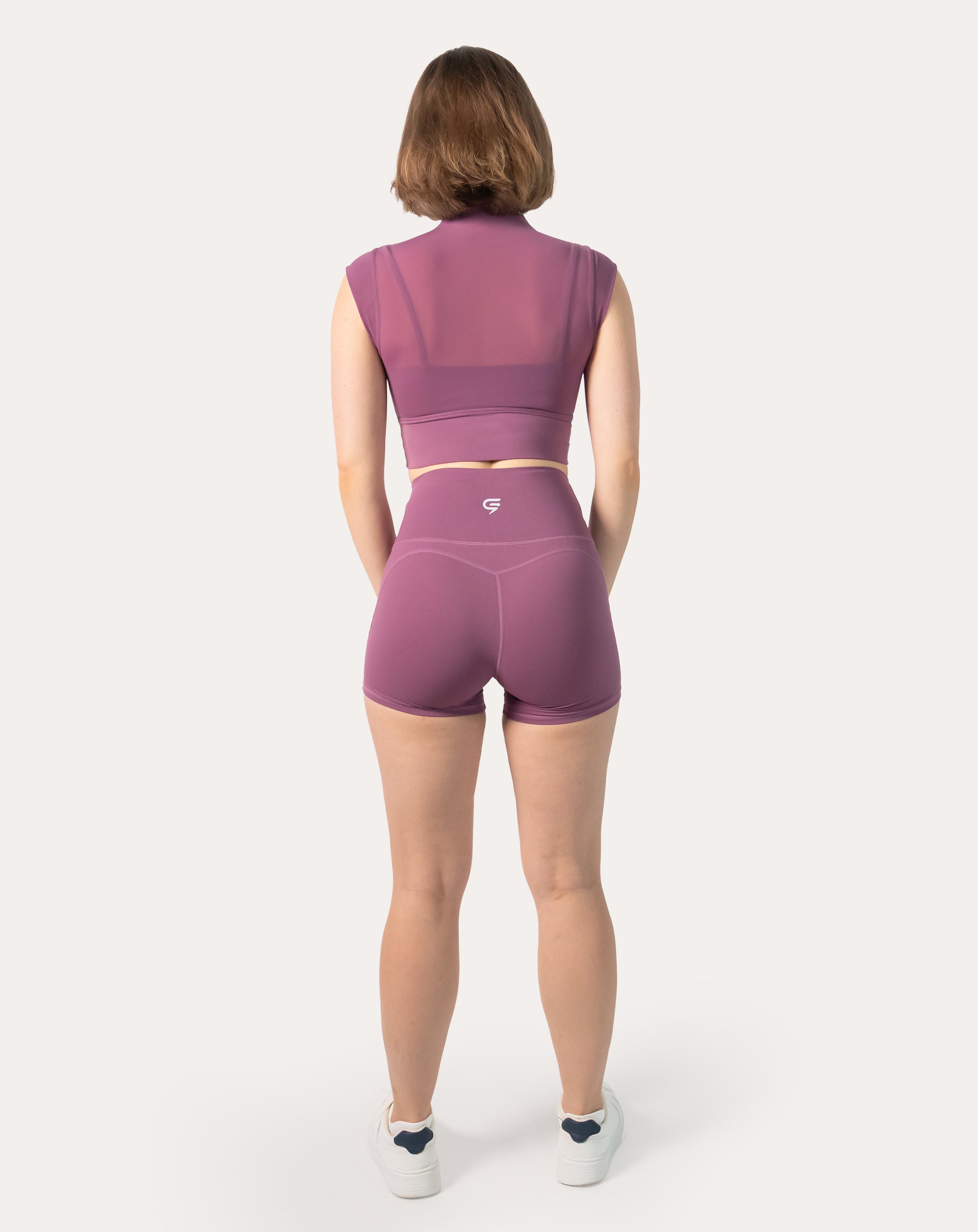 Back view highlighting breathable mesh back on crop top of plum gym shorts set