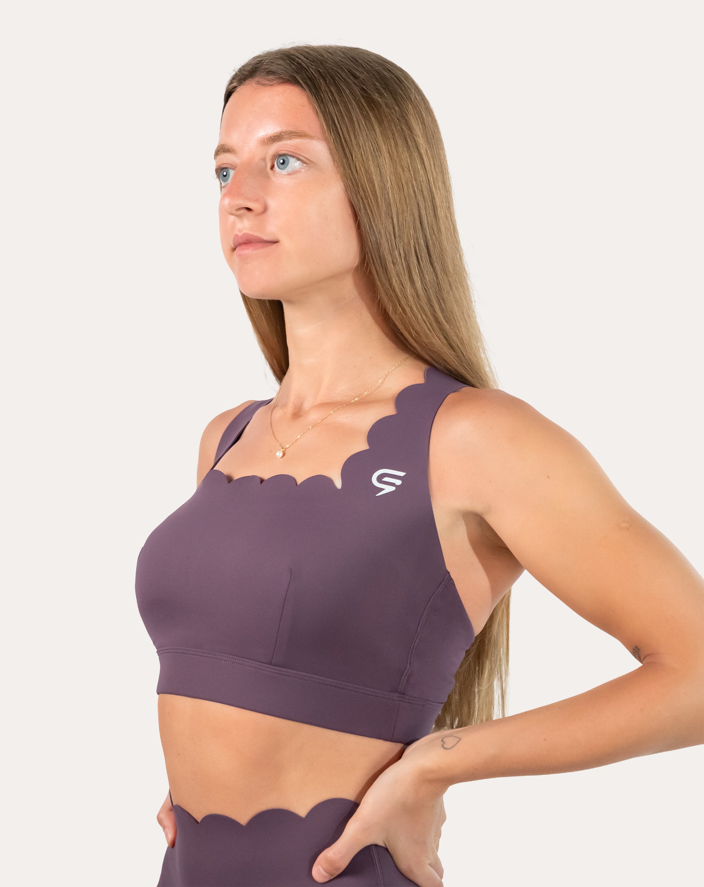 Front close-up of purple gym set bra showing scallop neckline and straps.