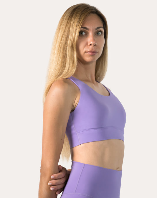Purple sports bra, three-quarter front with hands on hips showing scoop neckline