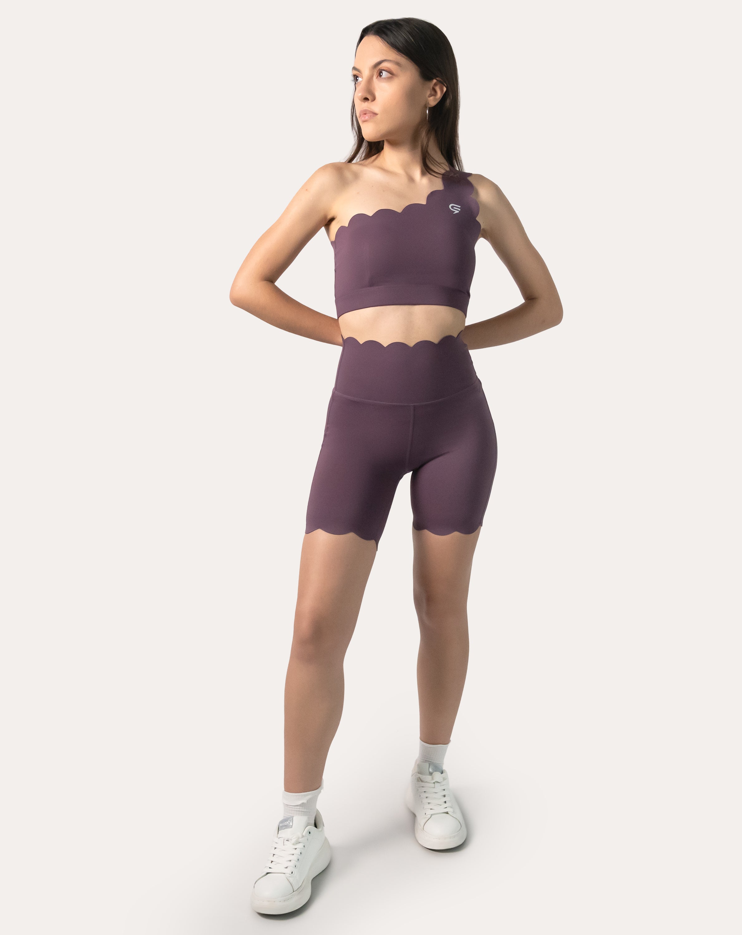 Full-body view of model wearing purple sports bra with matching shorts