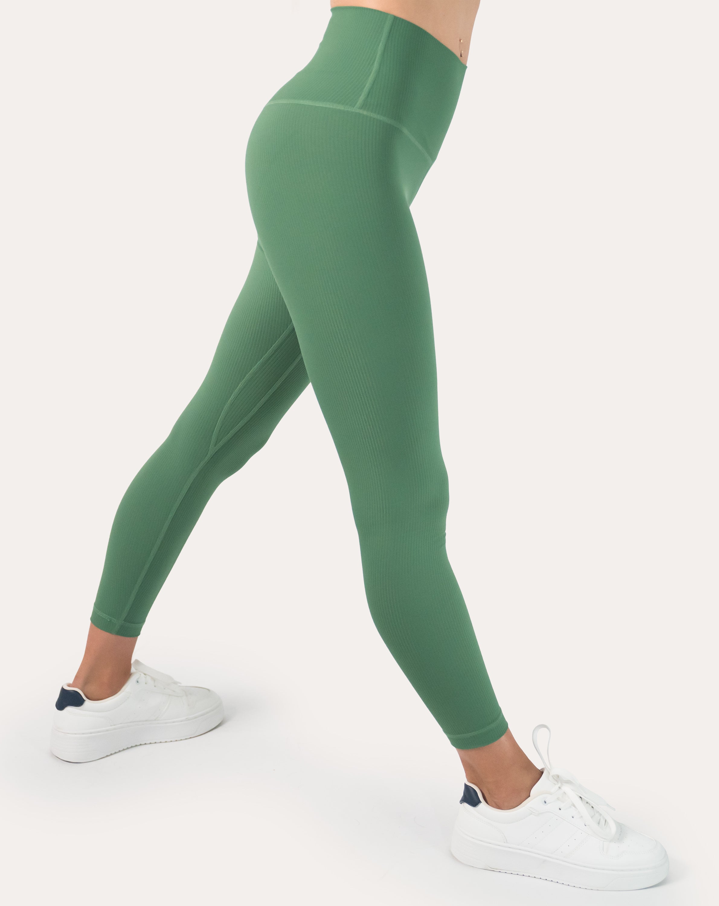 Side profile in a stretch showing flexible, squat-proof ribbed green high-waisted leggings; seamless fabric