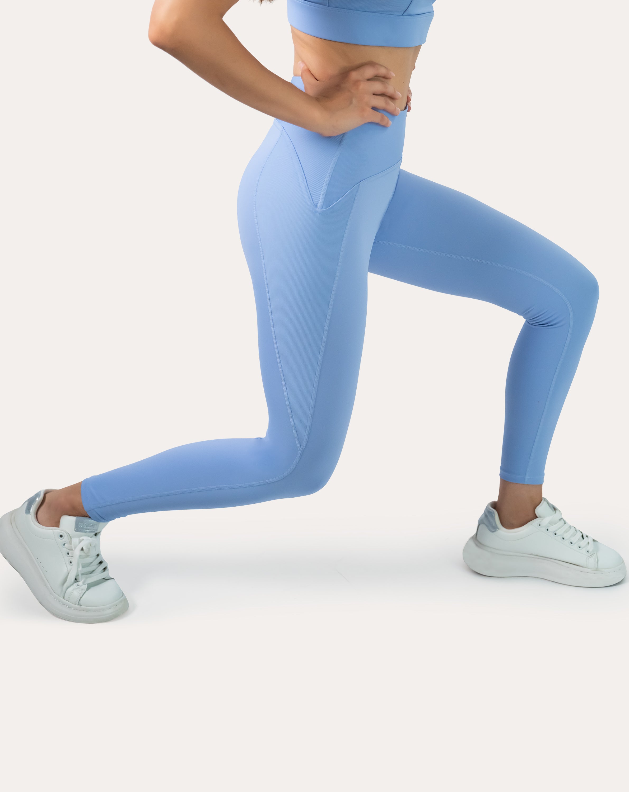 Light blue seamless gym leggings with V-contour high waistband; side lunge profile