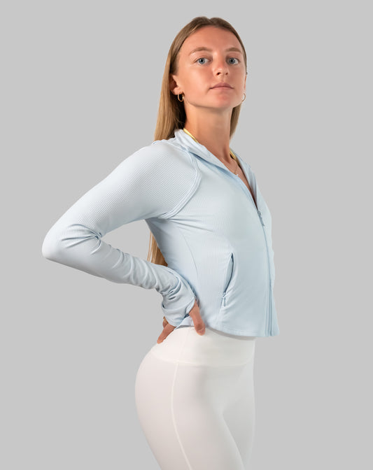 Track jacket women in powder blue, left three-quarter view with hands on hips