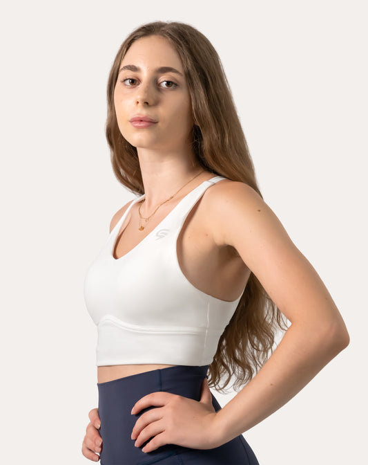 White backless sports bra with crisscross straps and V-neck, front three-quarter close-up