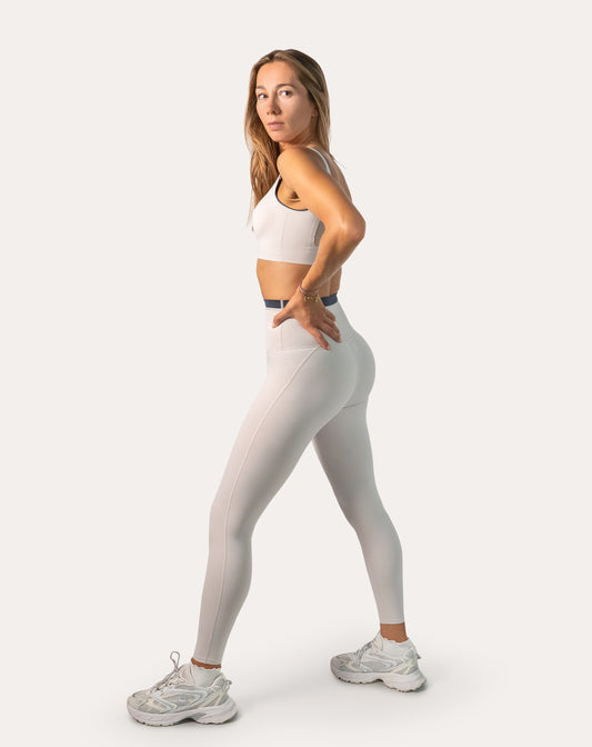 3/4 side view of white gym set for women showing smooth high-waist leggings and clean seams