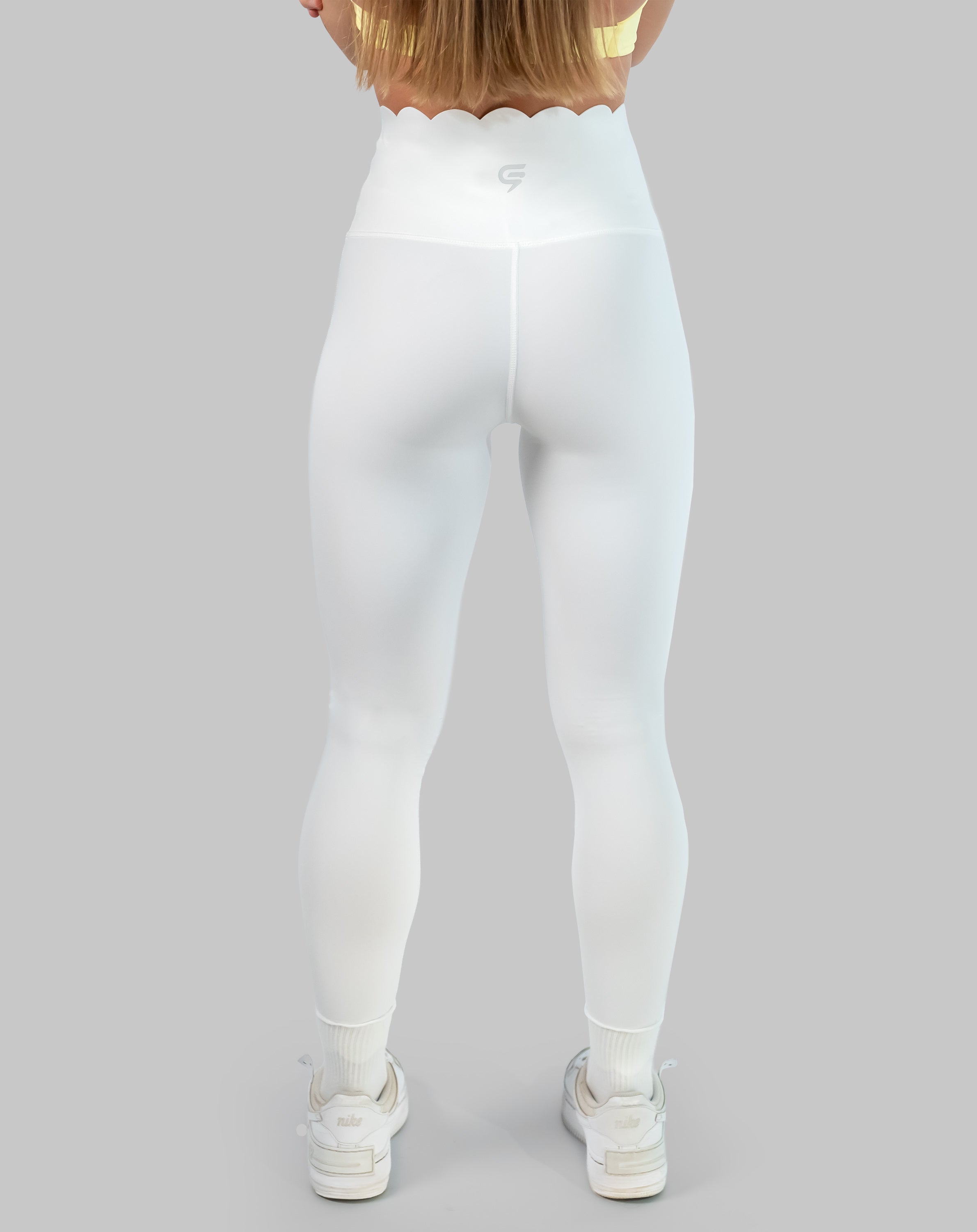 White leggings with high waisted scallop waistband, ankle length; back view