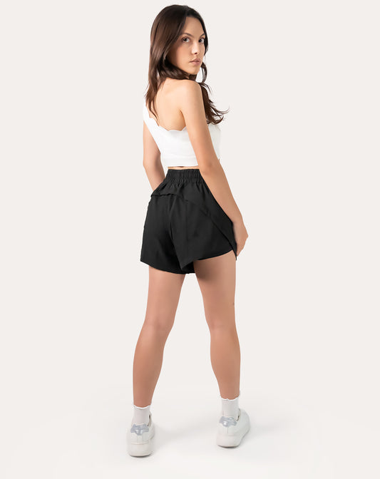 Full-body front three-quarter view of black women's 2-in-1 running shorts showing relaxed fit and split hem