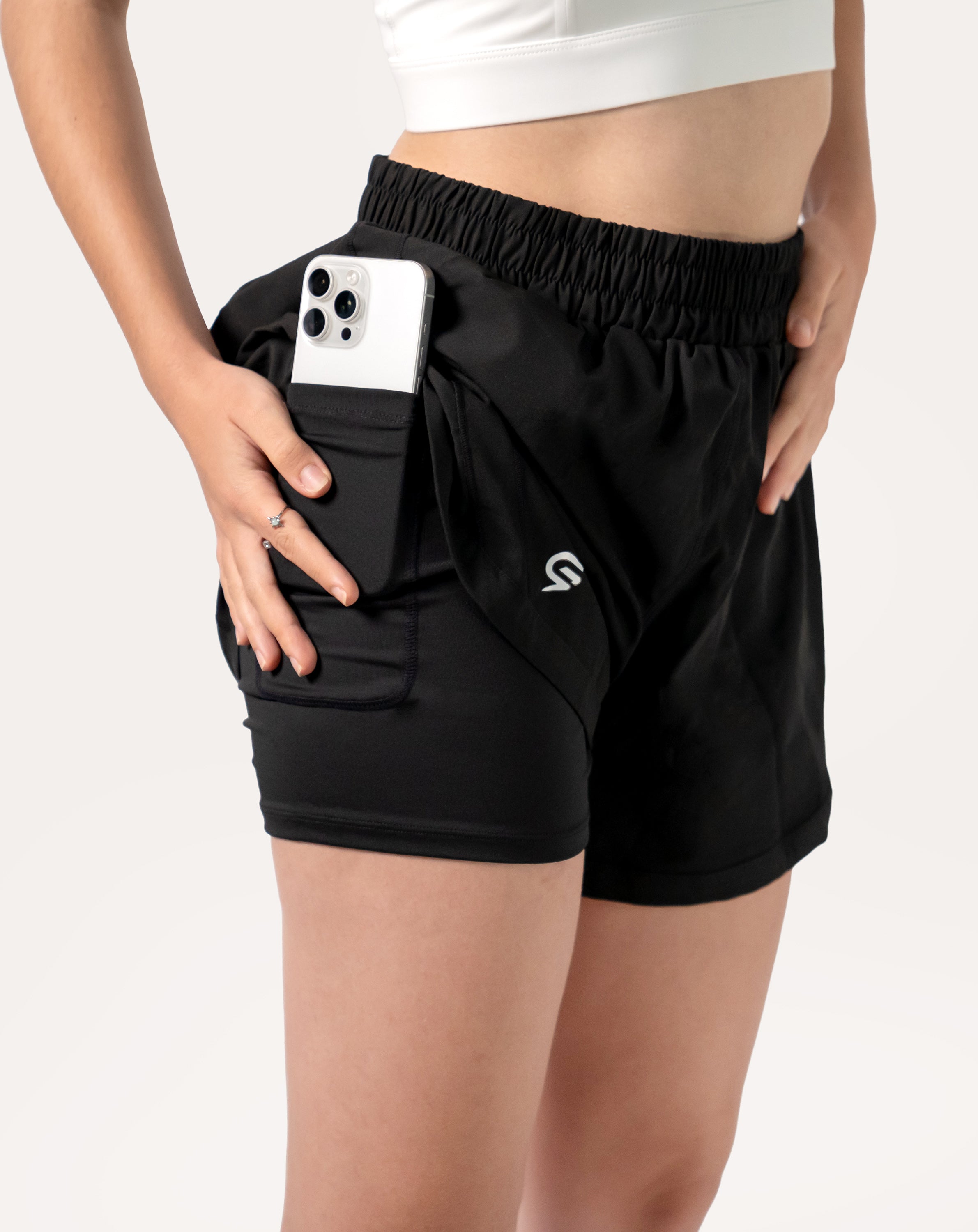 Side detail showing the phone pocket in the liner of black women's 2-in-1 running shorts