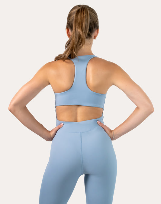 Sky blue women’s jumpsuit, racerback design shown from the back