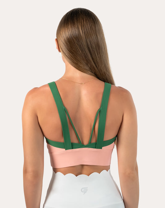 Back view of peach and green yoga sports bra with strappy open back and contrast green straps