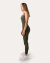 Left-side full-length view of olive athletic jumpsuit for women with sleek tapered legs