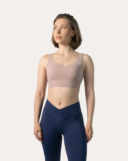 Full-length front view of baby pink sports bra paired with leggings