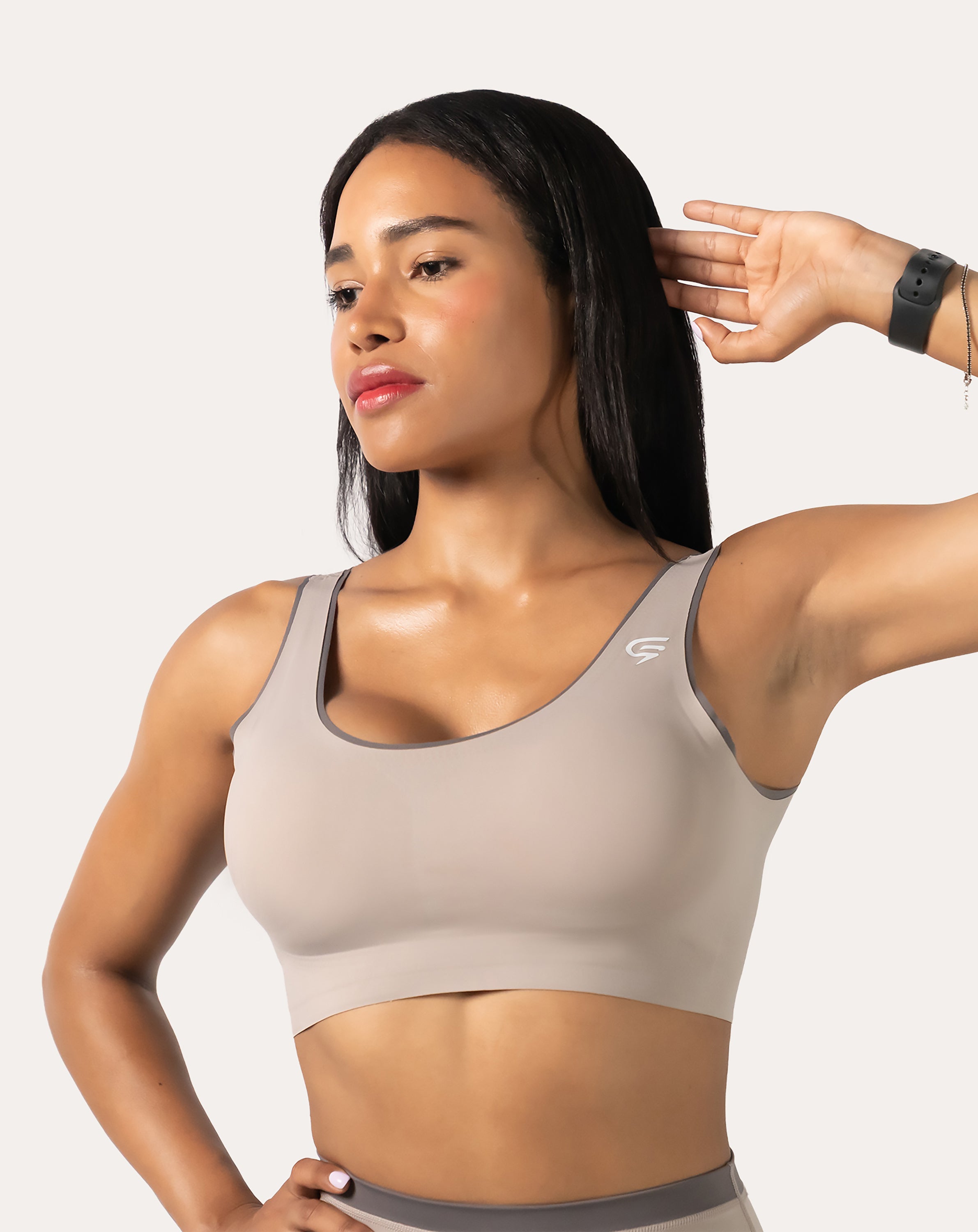 Beige high impact sports bra three-quarter front with hand in hair and smooth scoop front
