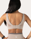 Close-up back of beige high impact sports bra highlighting mesh U-back panel