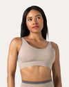 Beige high impact sports bra front close-up with scoop neck and wide straps