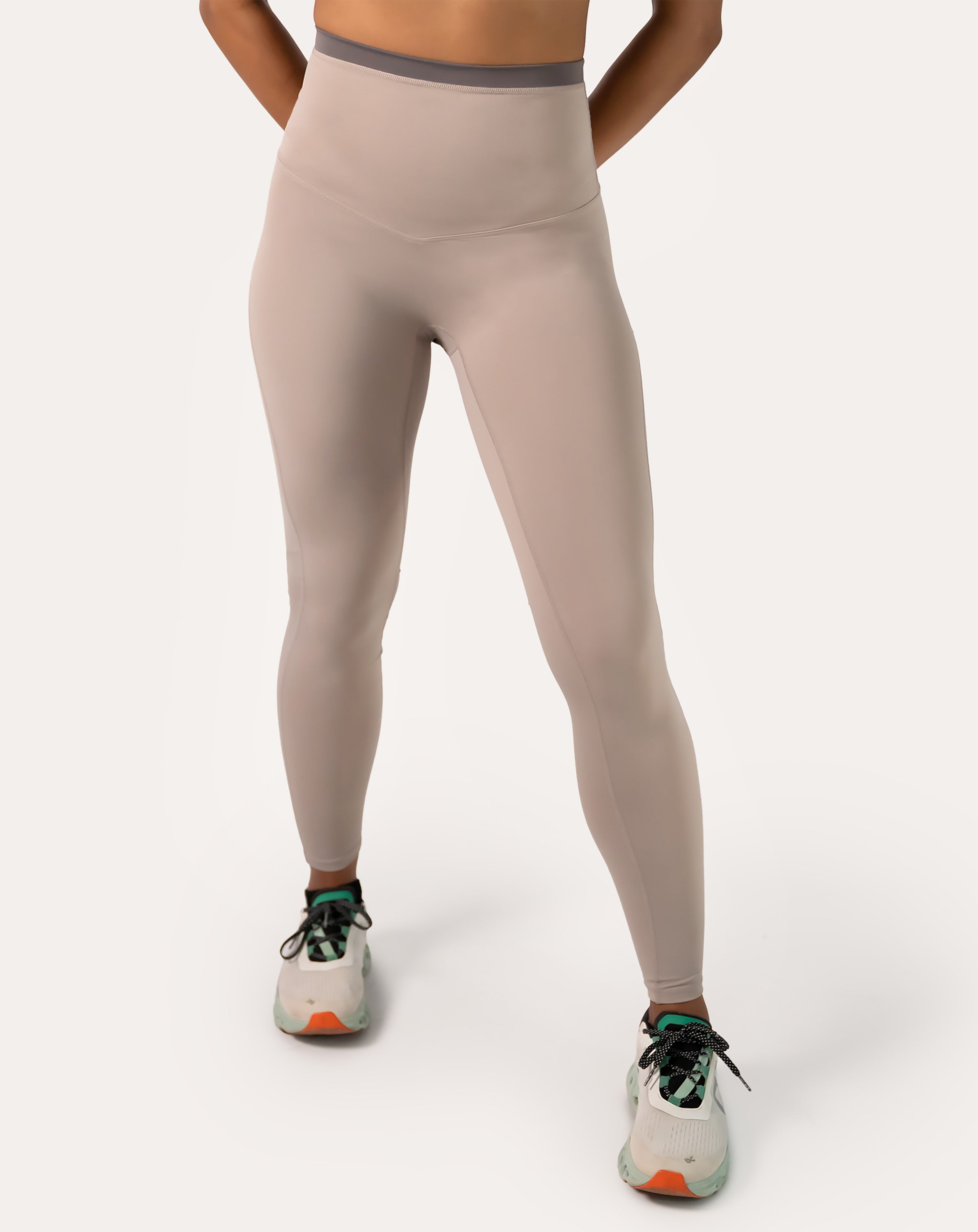 Full-body front view of taupe beige leggings with a sculpting high waist and opaque, squat-proof knit