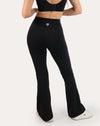 Back three-quarter close-up of black flared leggings with a high-waist bootcut fit