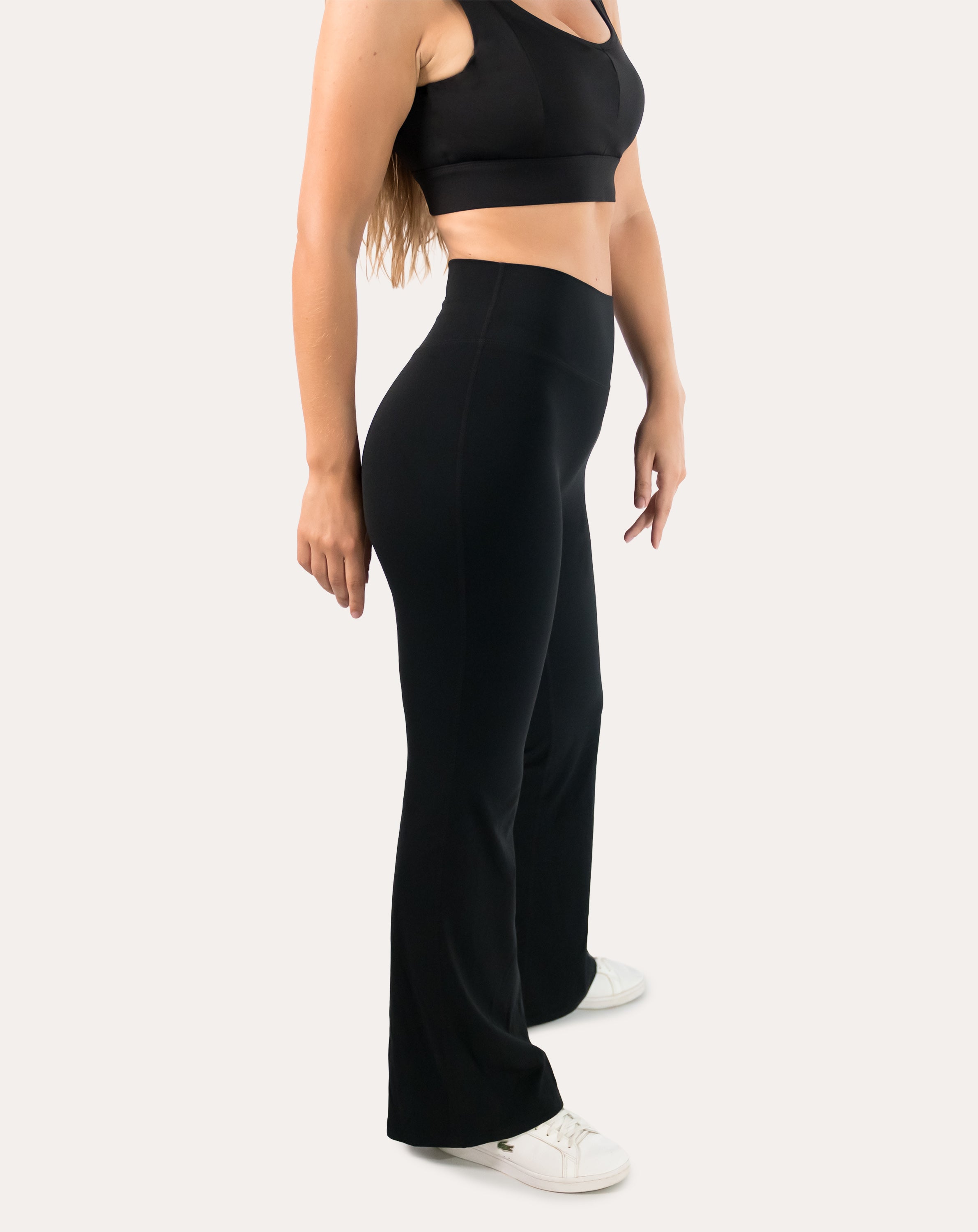 Full-body left side view of black flared leggings with high-waist bootcut silhouette
