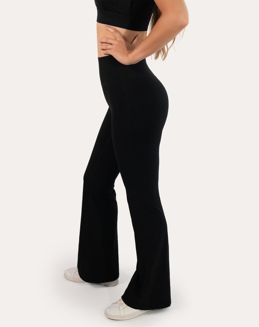 Right three-quarter angle highlighting the bootcut flare on black high-waist leggings
