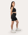 Three-quarter front pose of black gym shorts set showing longline bra and biker-length shorts