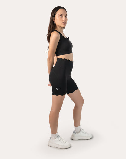 Three-quarter front pose of black gym shorts set showing longline bra and biker-length shorts