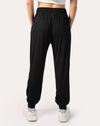 Back view of women’s black joggers featuring high waist and cuffed ankle finish