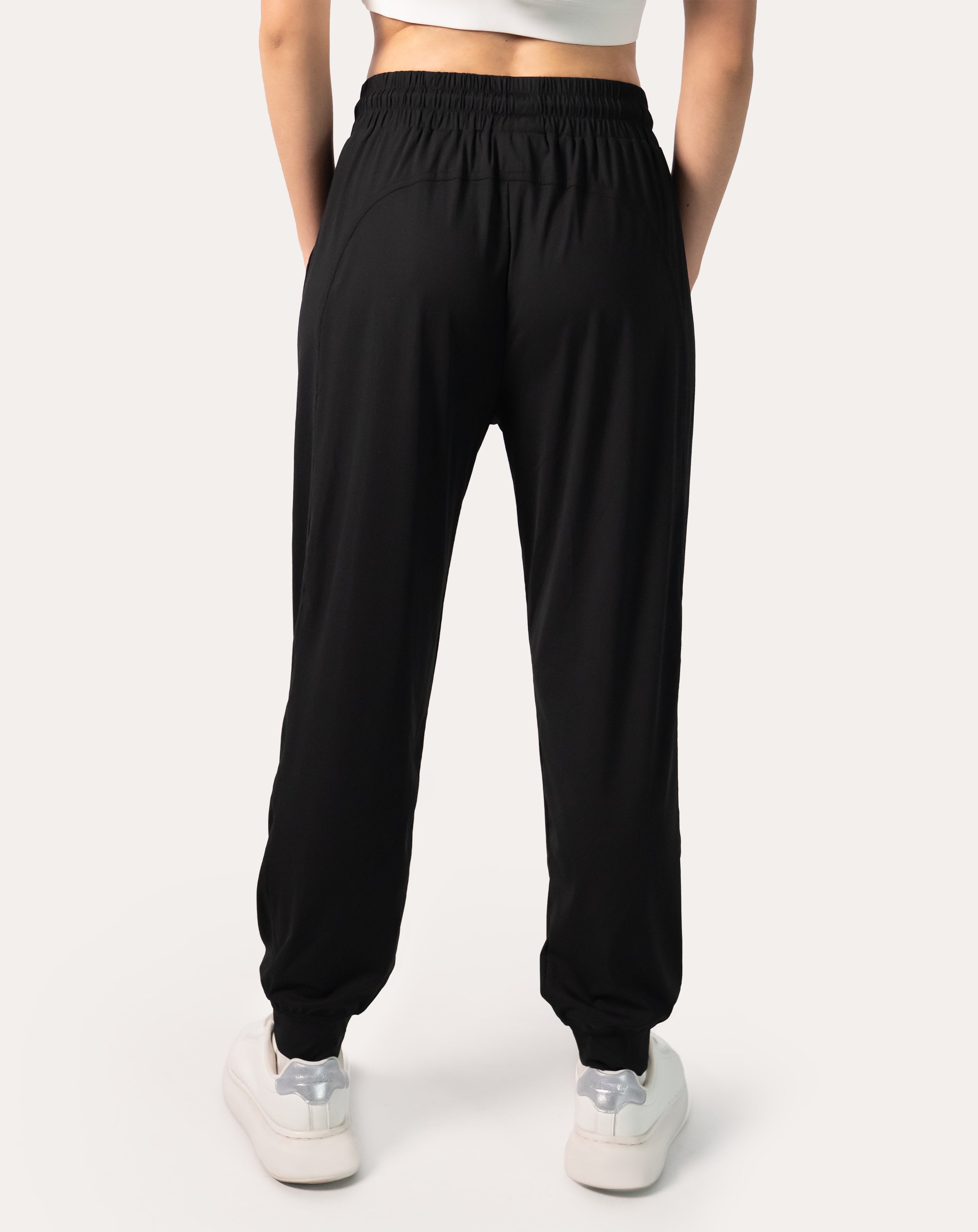 Back view of women’s black joggers featuring high waist and cuffed ankle finish