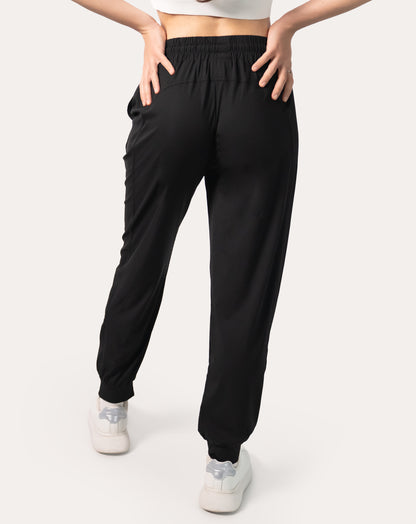 Back full-length view of black joggers for women with elastic waistband and cuffed ankles