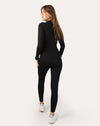 Back full-body view of black long-sleeve women’s jumpsuit showing streamlined fit