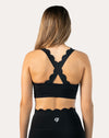 Straight back view of black padded sports bra highlighting cross-back straps and wide underband