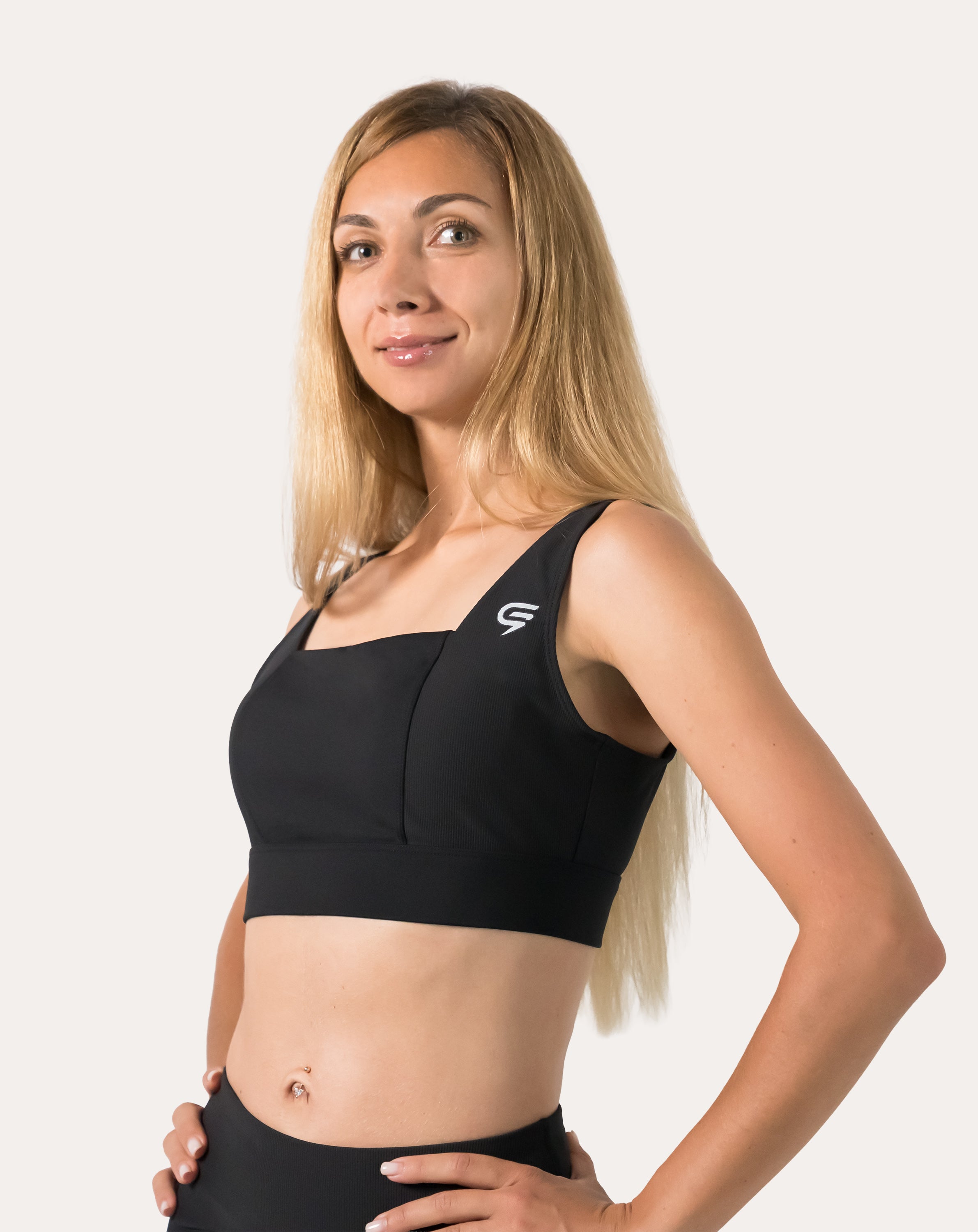 Front three-quarter view of black running sports bra with square neck and wide straps