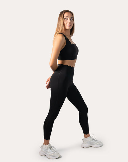 Side profile of black seamless gym set highlighting longline bra and sculpting leggings