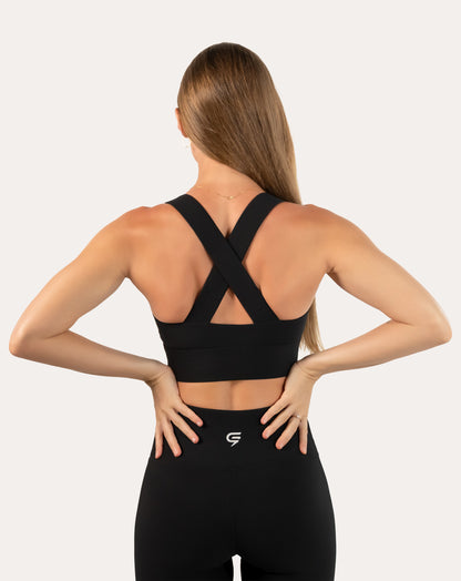 Back view of black sports bra with cross-back straps and wide underband