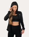 Front view with hood up of black women’s zip-up jacket, thumbhole cuffs visible